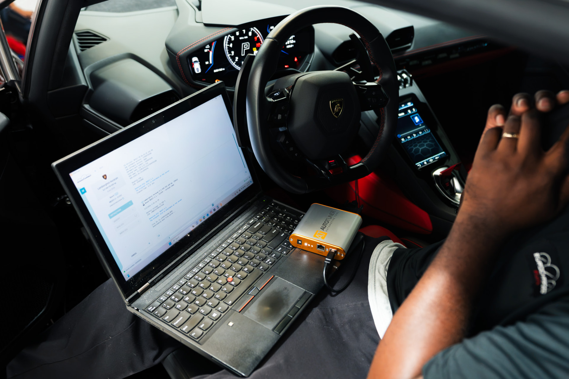 Laptop and AutoTuner device writing an ECU tune inside a car