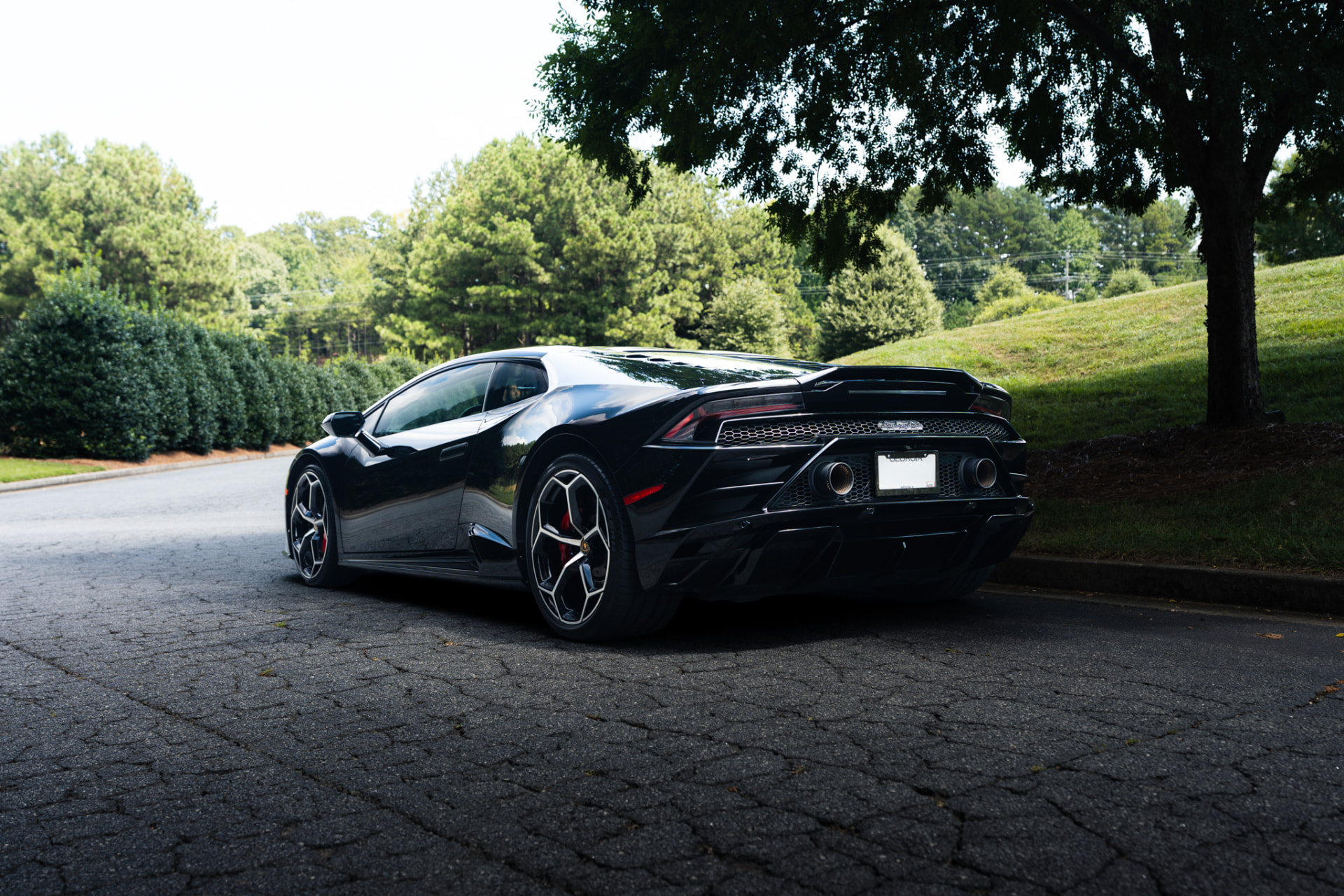 Black Lamborghini Huracán rear three-quarter view showing the exhausts