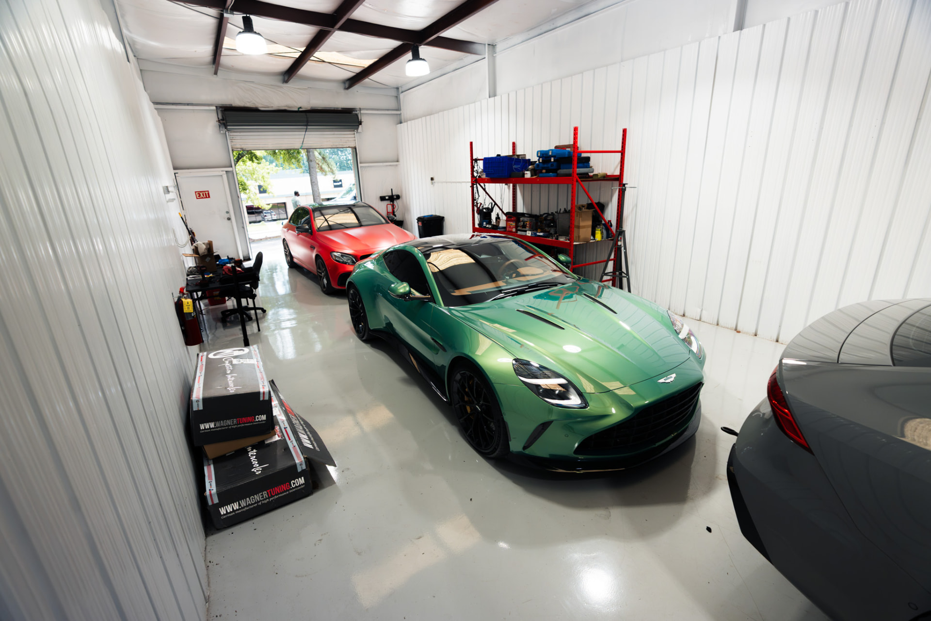 Green Aston Martin and red Mercedes-AMG inside the Eurocharged Atlanta shop