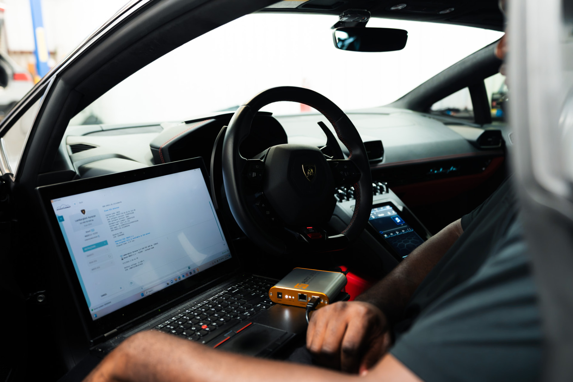 ECU tuning session in progress: laptop and AutoTuner connected inside a Lamborghini