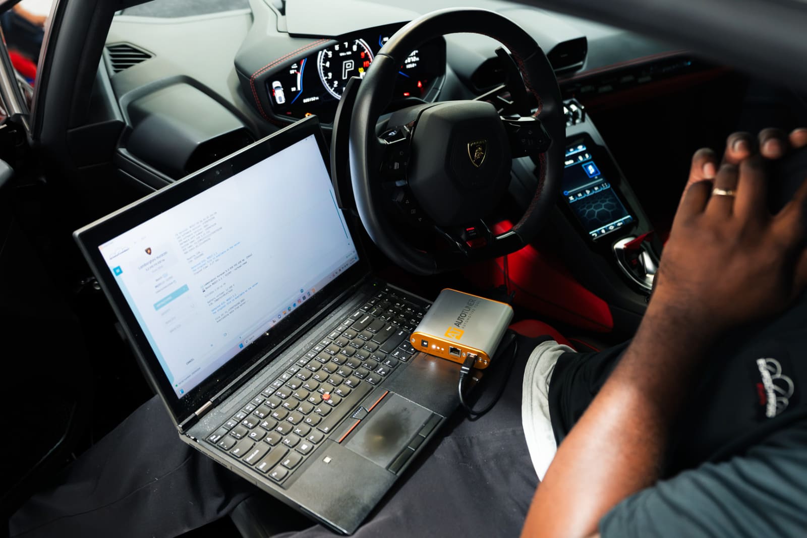 A Eurocharged technician writing an ECU tune to a Lamborghini with a laptop and an AutoTuner