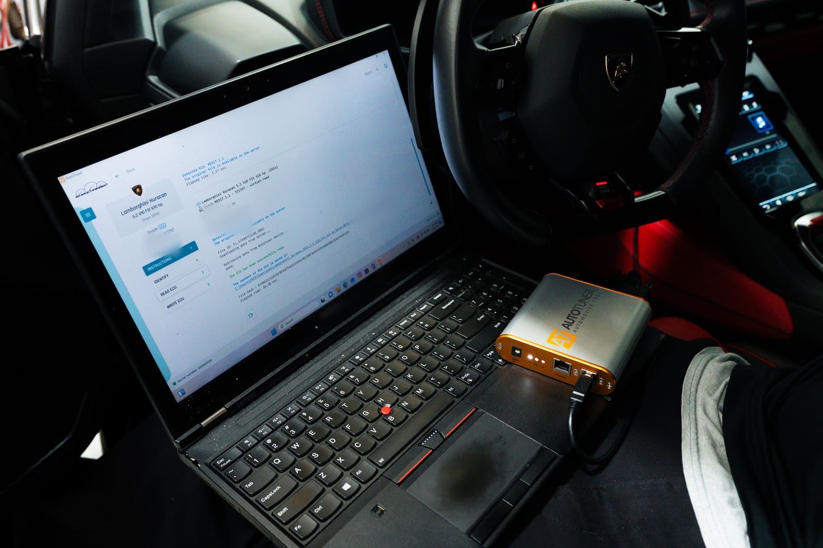 Laptop running AutoTuner beside the steering wheel of a Lamborghini Huracán, showing the ECU read as complete