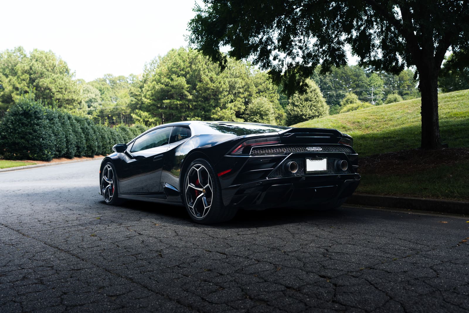 Black Lamborghini Huracán from the rear three-quarter, showing its exhausts