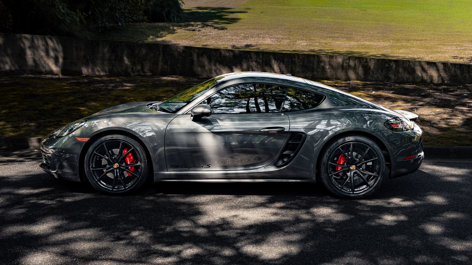 Grey Porsche 718 Cayman S in profile, with red brake calipers